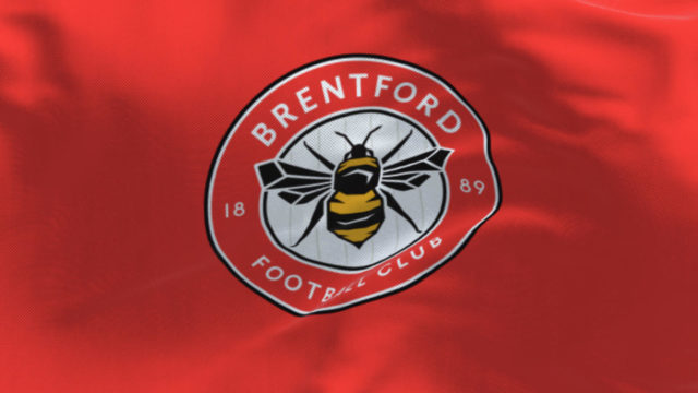 Brentford Football Club flag waving in the wind on a clear day.