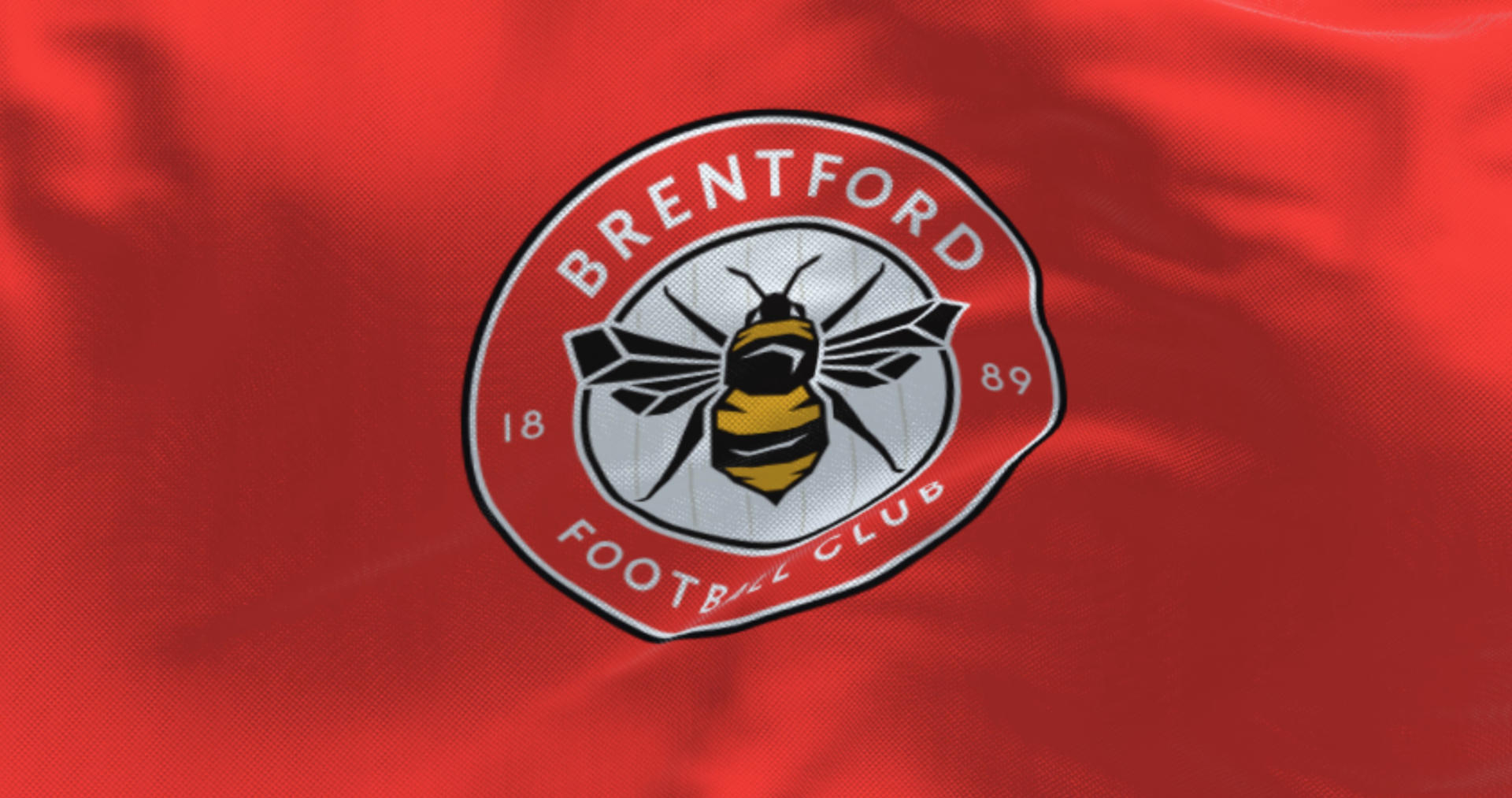 Brentford Football Club flag waving in the wind on a clear day.