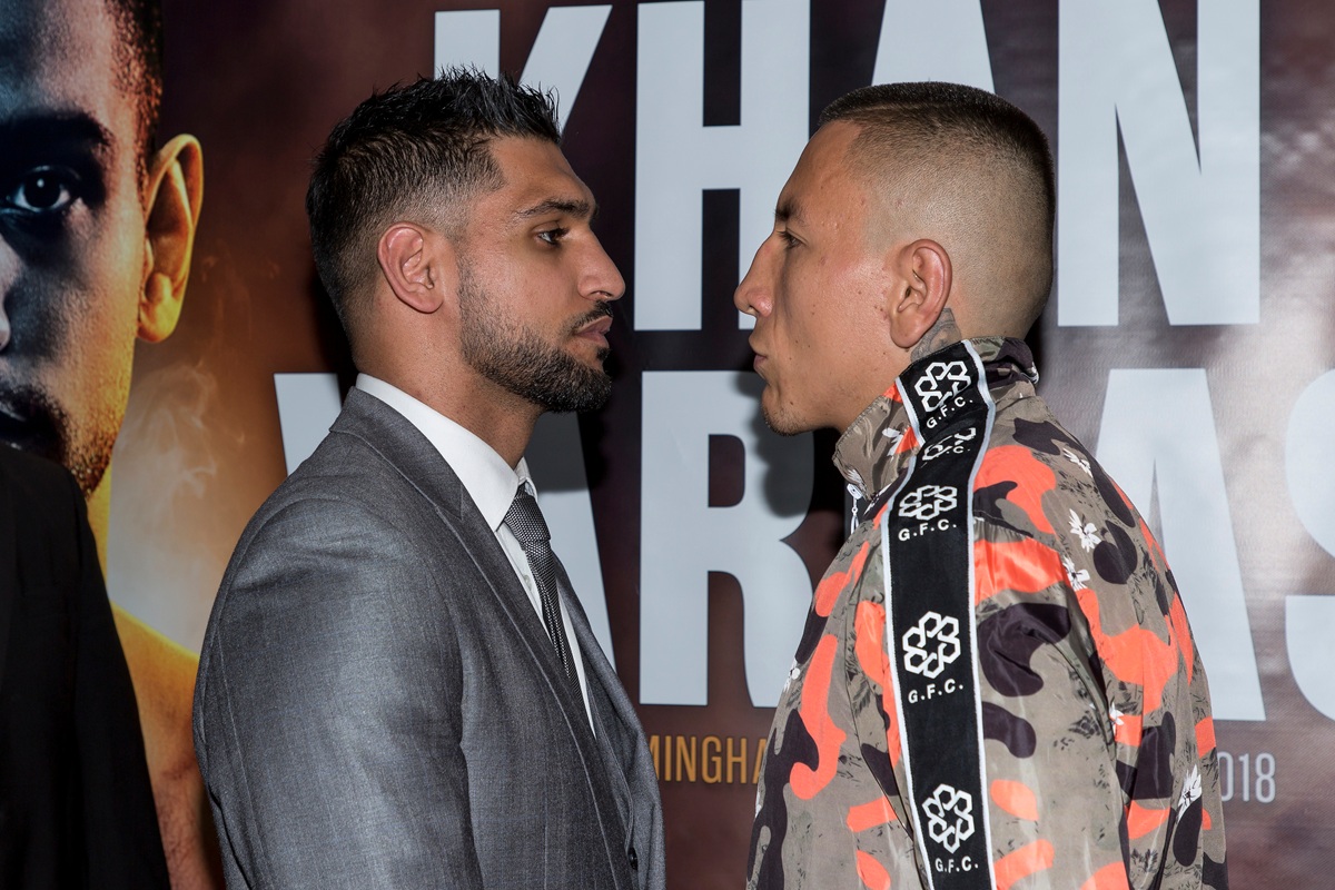 Amir Khan celebrating in the boxing ring with a world title belt over his shoulder