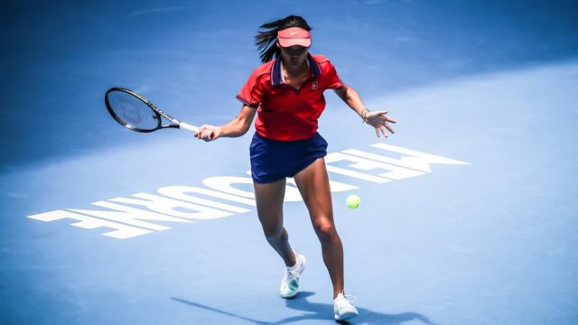 "Emma Raducanu smiling while holding the US Open trophy – 2021 Grand Slam winner"