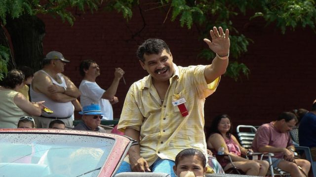 Alexis Argüello in the boxing ring during a title fight, wearing red gloves and white trunks, focused and ready to strike.