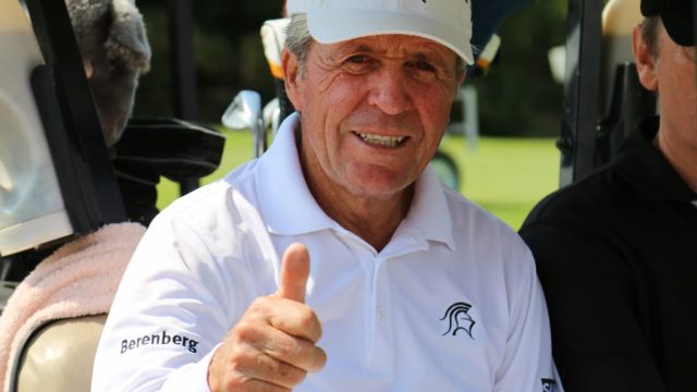 Gary Player swinging golf club on the course, smiling