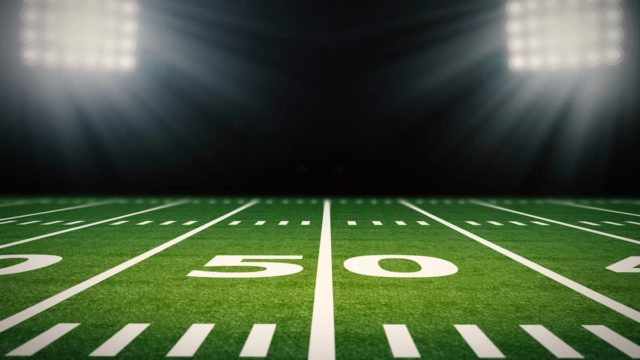 Historical photo showing early American football players on a field in vintage gear