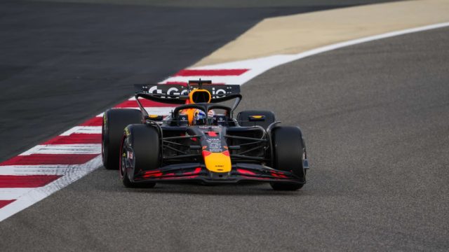Max Verstappen smiling in Red Bull Racing gear at a Formula 1 track in 2025