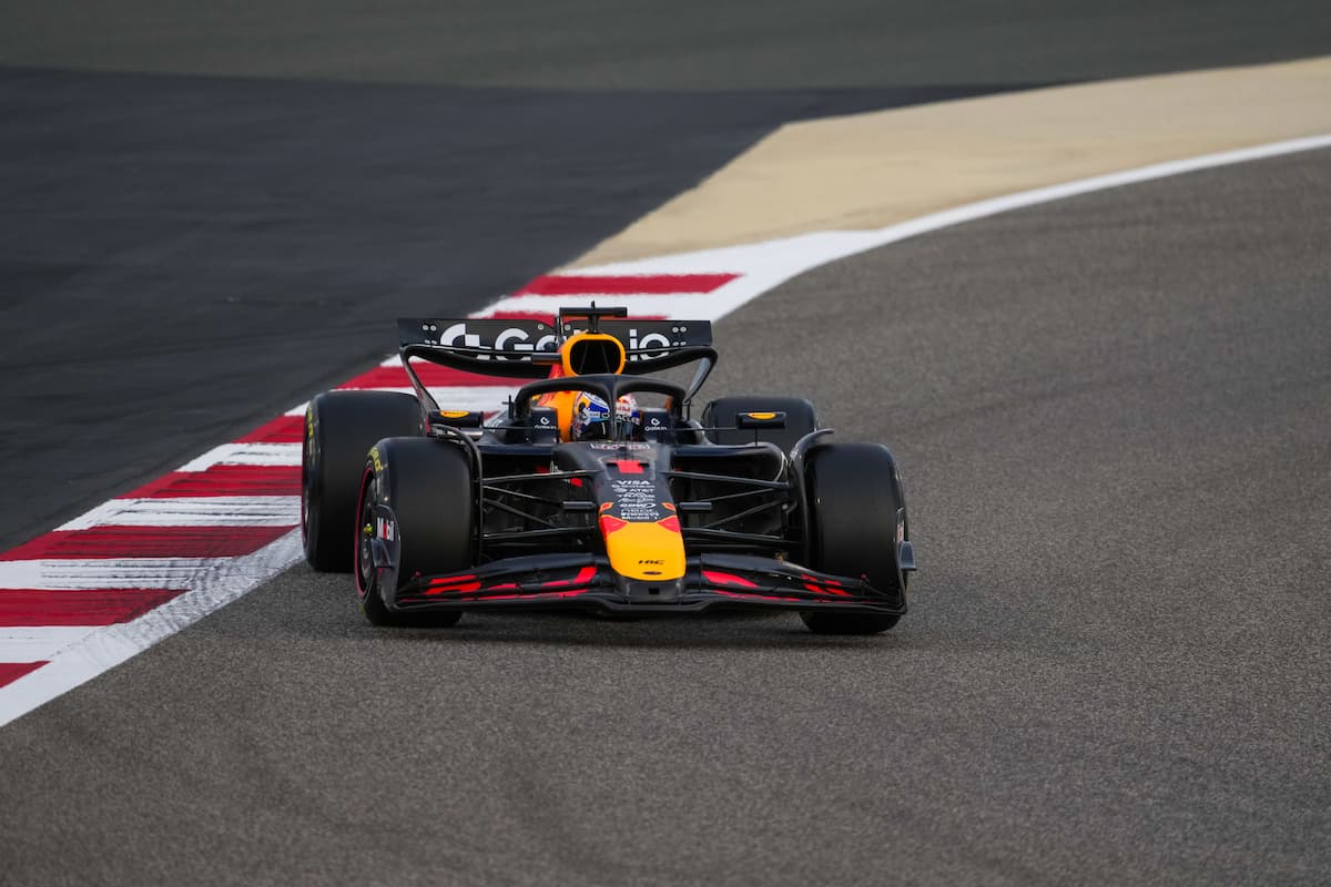 Max Verstappen smiling in Red Bull Racing gear at a Formula 1 track in 2025
