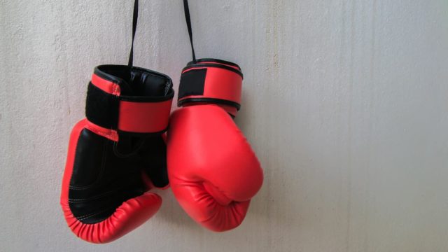 Michael Spinks in boxing gear, posing with championship belts