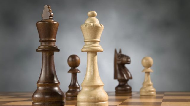 Wooden chess coins placed on a chessboard with their names
