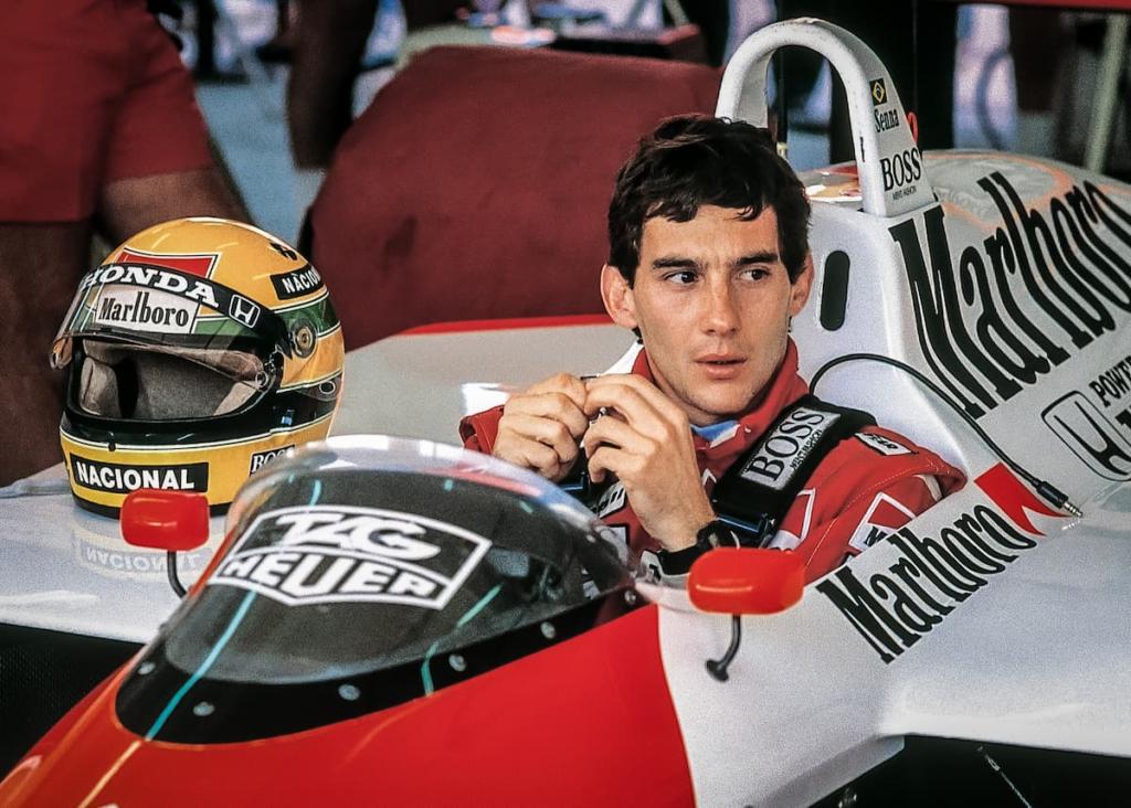 Ayrton Senna in racing gear next to Formula One car
