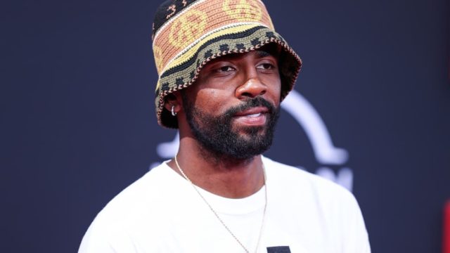 Kyrie Irving during an NBA game with financial figures in the background