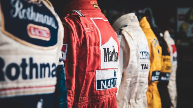 Top F1 drivers of all time standing beside Formula 1 cars