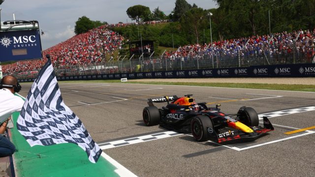 F1 drivers celebrating on the podium with confetti and chequered flag to illustrate Formula 1 prize money