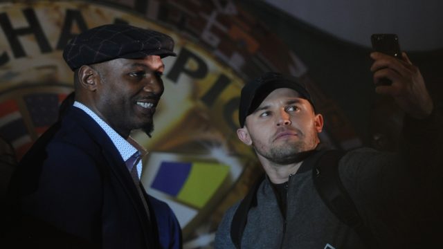 Lennox Lewis net worth and career earnings highlighted as he poses with his world heavyweight title belts in the ring.