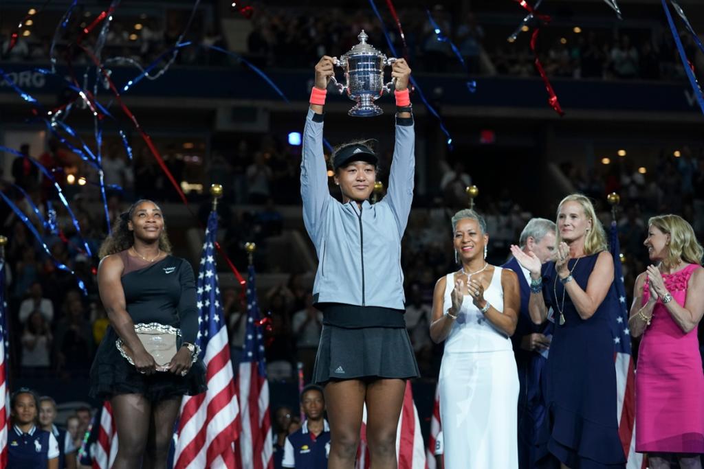 Naomi Osaka Net Worth:: Osaka holding a tennis trophy on court