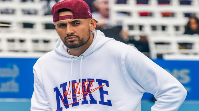 Nick Kyrgios celebrating after a match with fans in the background
