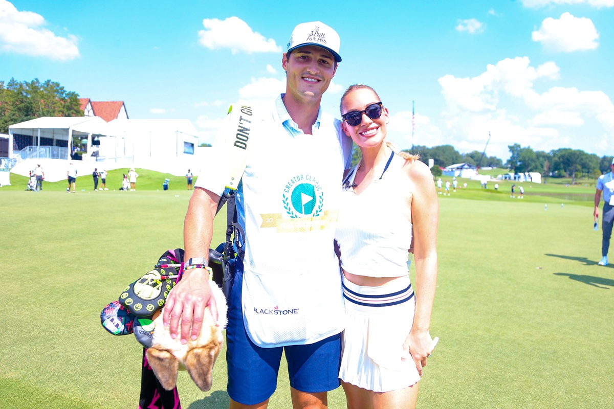 Paige Spiranac wearing a teal top and white skirt at a PGA Tour creator event