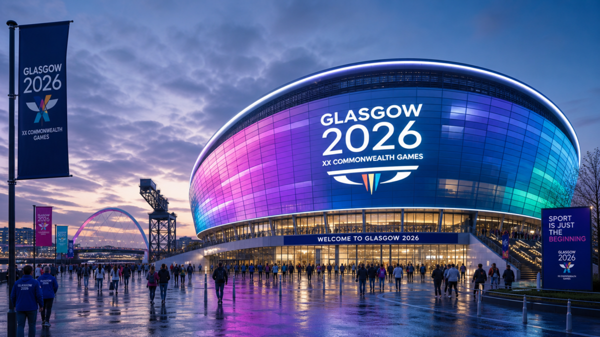 Glasgow 2026 Commonwealth Games arena lit up at dusk, with crowds outside on a