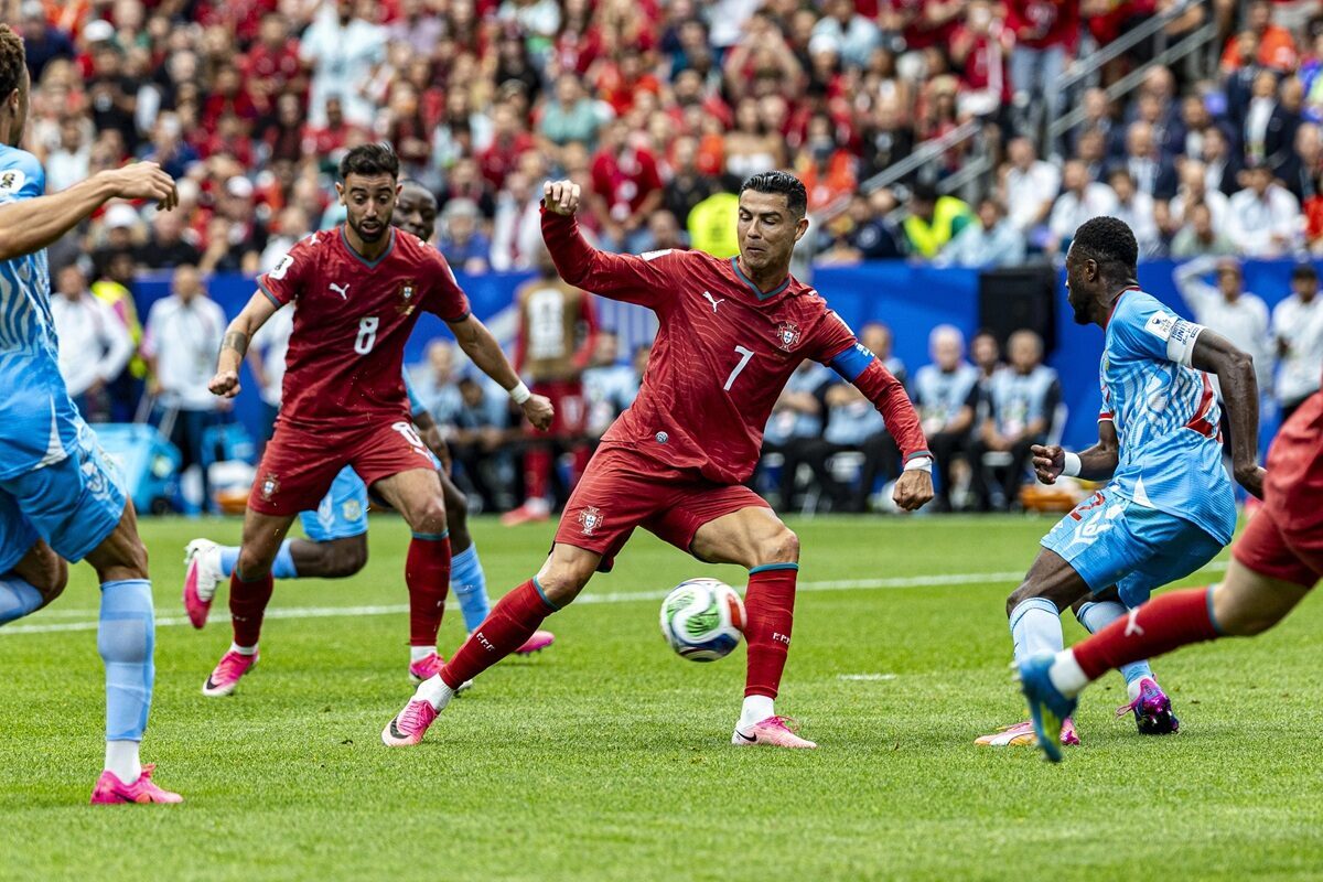 Portugal player Cristiano Ronaldo controls the ball under pressure from opponents in a football match